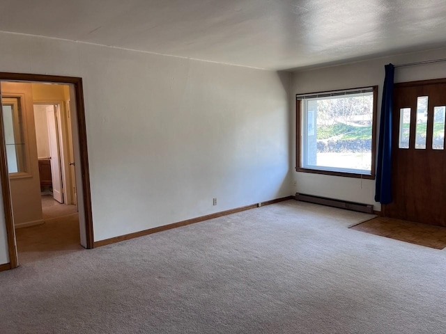 spare room with baseboard heating, a wealth of natural light, and carpet floors