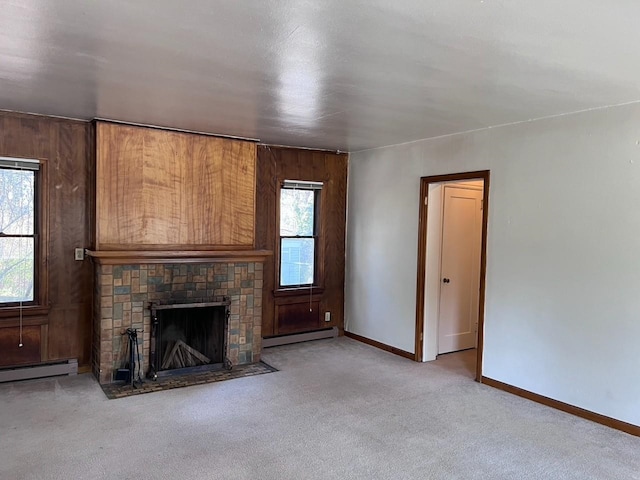 unfurnished living room with carpet flooring, a baseboard radiator, baseboard heating, baseboards, and a brick fireplace