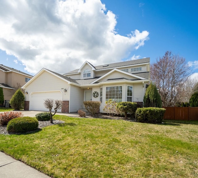 traditional-style house featuring a garage, fence, a front lawn, brick siding, and concrete driveway