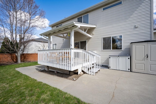 exterior space with a wooden deck, a storage shed, a yard, an outdoor structure, and fence