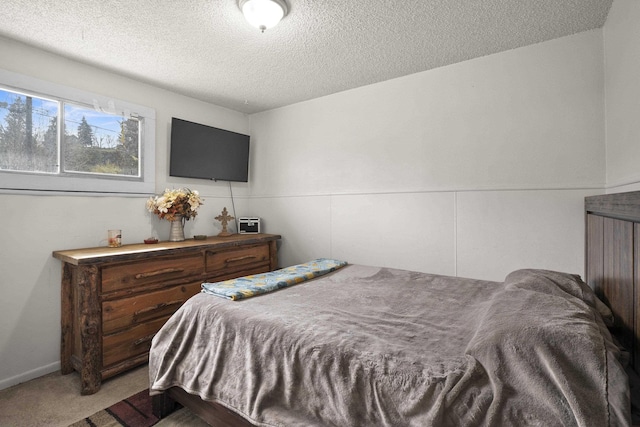 bedroom featuring a textured ceiling and light colored carpet