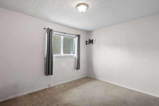 unfurnished room featuring baseboards, visible vents, carpet floors, and a textured ceiling