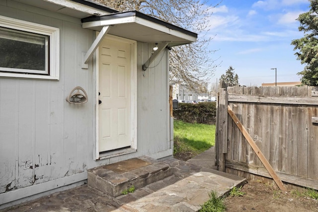 view of exterior entry featuring fence