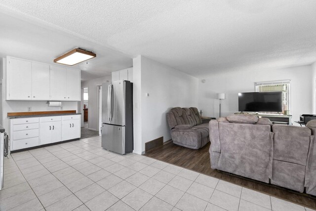 2218 E Hartson Ave, Spokane, WA 99202 - kitchen with stainless steel appliances, under cabinet range hood, healthy amount of natural light, white cabinets, and a textured ceiling