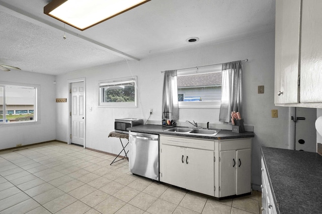 kitchen featuring a wealth of natural light, dark countertops, stainless steel appliances, and a sink