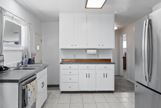 2218 E Hartson Ave, Spokane, WA 99202 - kitchen with appliances with stainless steel finishes, dark countertops, white cabinetry, and light tile patterned floors