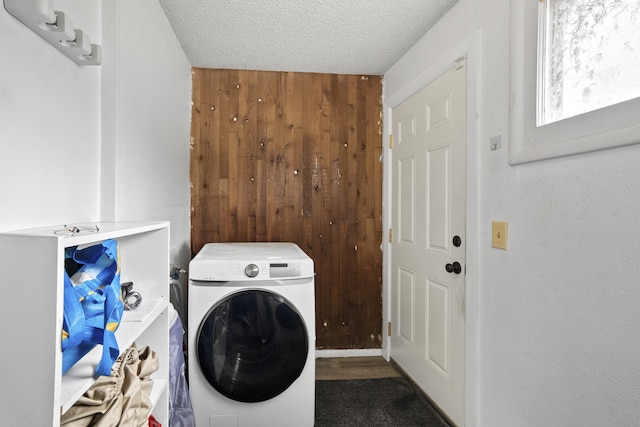 clothes washing area with washer / dryer, a textured ceiling, and laundry area