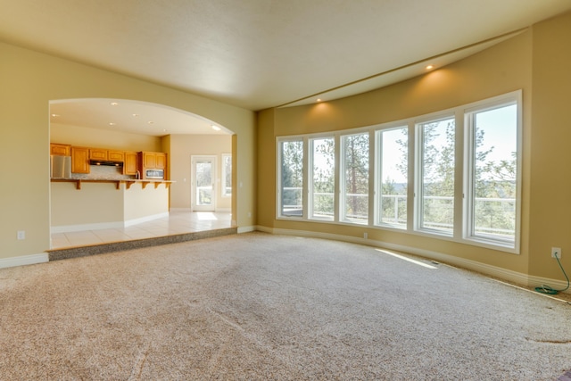 6519 W Kitsap Dr, Spokane, WA 99208 - unfurnished living room with baseboards, recessed lighting, arched walkways, and light carpet