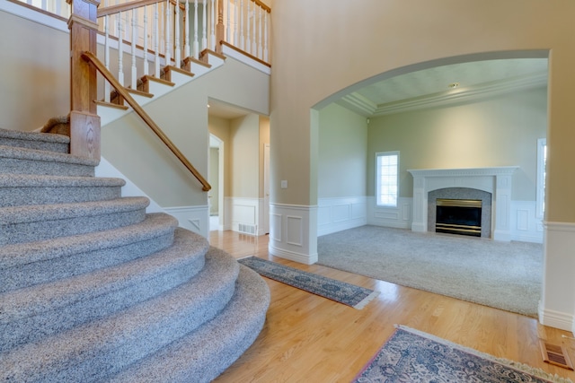 6519 W Kitsap Dr, Spokane, WA 99208 - foyer entrance with arched walkways, wood finished floors, stairs, a wainscoted wall, and a fireplace