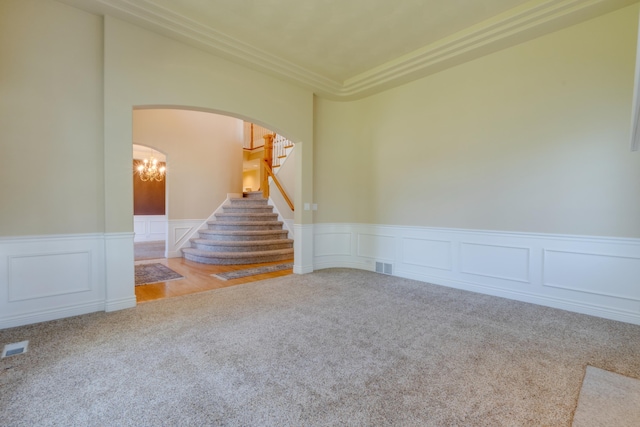6519 W Kitsap Dr, Spokane, WA 99208 - carpeted spare room with stairway, visible vents, wainscoting, and arched walkways