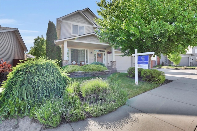 6610 S Springview St, Spokane, WA 99224 - view of front of property featuring driveway, an attached garage, stone siding, and covered porch