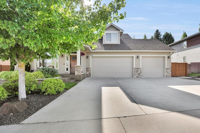 6610 S Springview St, Spokane, WA 99224 - view of property hidden behind natural elements with a garage, stone siding, concrete driveway, and roof with shingles