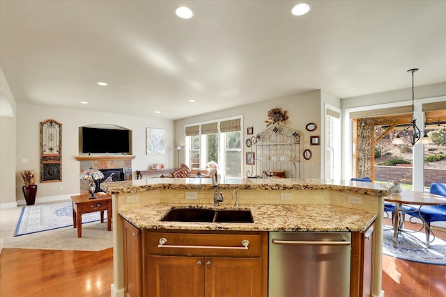 6610 S Springview St, Spokane, WA 99224 - kitchen with open floor plan, wood finished floors, stainless steel dishwasher, hanging light fixtures, and a fireplace
