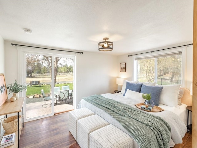 bedroom with access to outside and wood finished floors