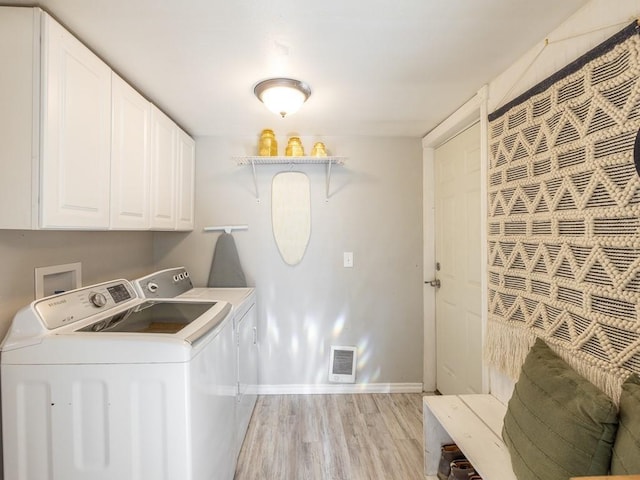 clothes washing area with visible vents, baseboards, light wood finished floors, cabinet space, and washing machine and dryer