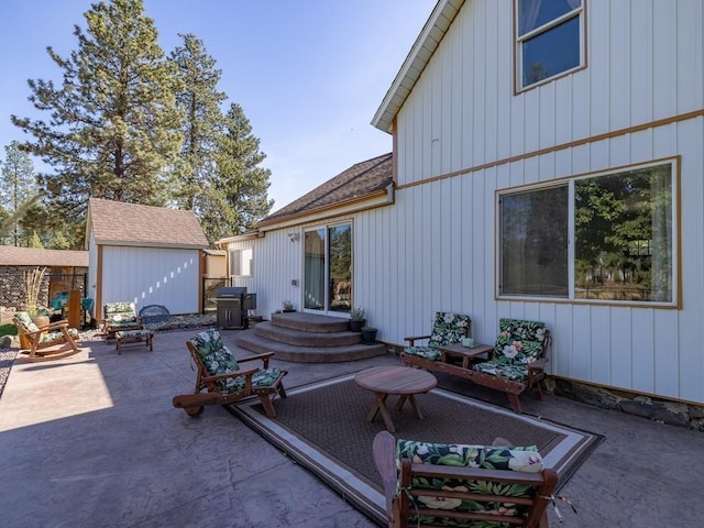 back of house with an outdoor structure, a patio area, fence, a shingled roof, and a storage unit