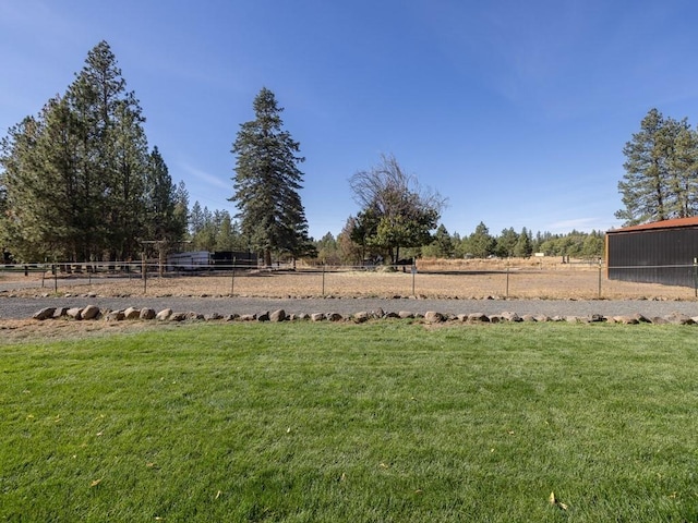 view of yard with a rural view and fence