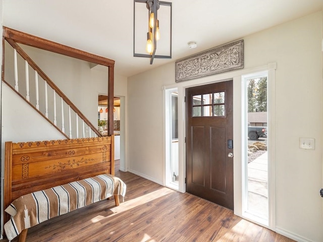 foyer with wood finished floors, baseboards, and stairs