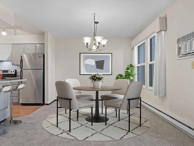 dining room featuring track lighting, a baseboard heating unit, a chandelier, a textured ceiling, and light colored carpet