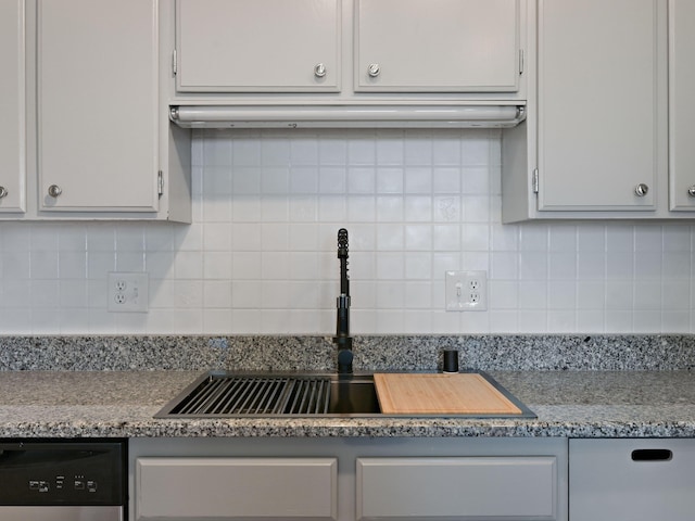 kitchen featuring dishwasher, white cabinetry, a sink, and decorative backsplash