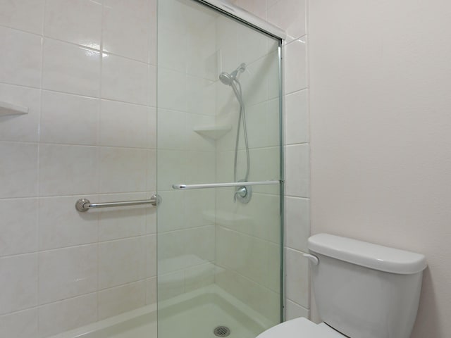 bathroom featuring a shower stall and toilet