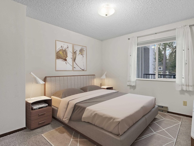 carpeted bedroom with baseboards, baseboard heating, and a textured ceiling