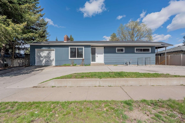 ranch-style house with a chimney, a garage, fence, and concrete driveway
