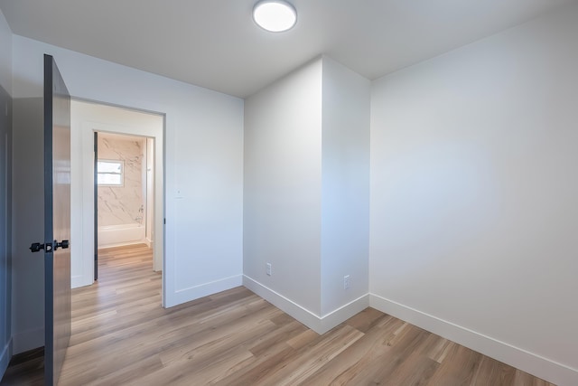 unfurnished room with light wood finished floors and baseboards