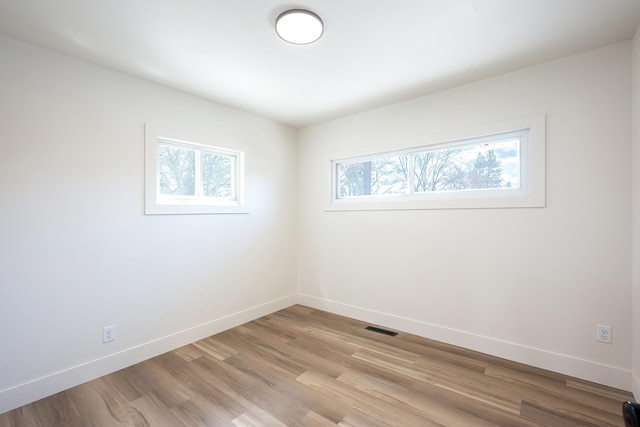 unfurnished room with a healthy amount of sunlight, baseboards, and visible vents