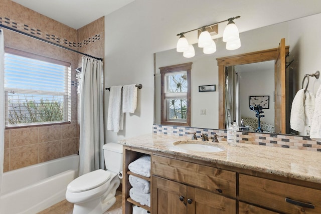 bathroom featuring toilet, tasteful backsplash, vanity, and a wealth of natural light