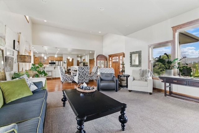 living area featuring recessed lighting, a high ceiling, and baseboards