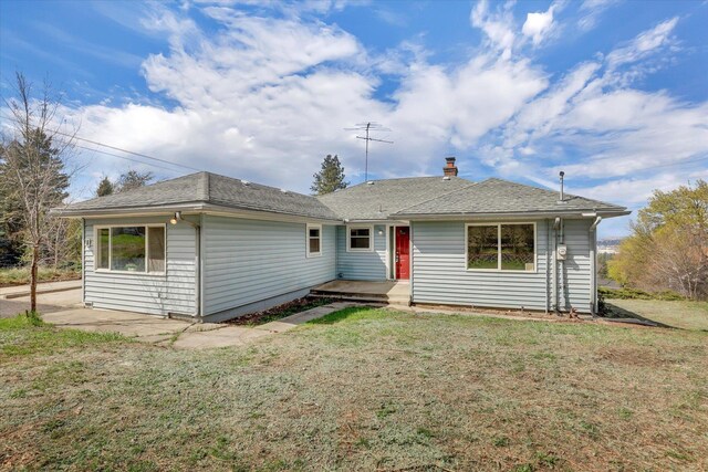 view of front of house with a front yard and roof with shingles