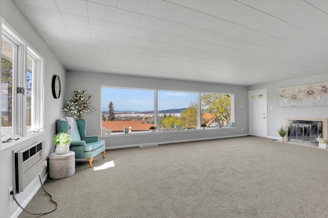living area featuring baseboards, carpet, and a fireplace with flush hearth