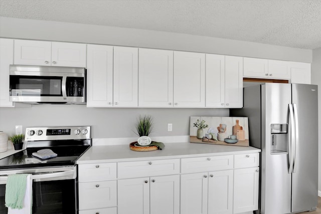 kitchen featuring white cabinets, light countertops, appliances with stainless steel finishes, and a textured ceiling