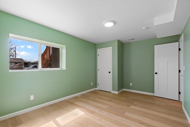 703 E Kiernan Ave, Spokane, WA 99207 - unfurnished bedroom featuring baseboards, wood finished floors, and visible vents