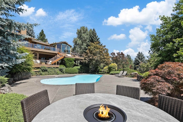 7816 E Gunning Ln, Spokane, WA 99212 - swimming pool featuring stairs, a patio, outdoor dining area, a wooden deck, and a fire pit