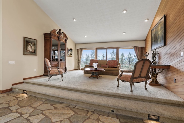 7816 E Gunning Ln, Spokane, WA 99212 - carpeted living room with wooden walls, a high ceiling, and recessed lighting