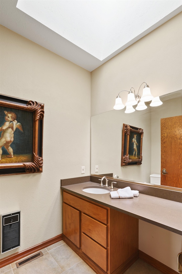 7816 E Gunning Ln, Spokane, WA 99212 - bathroom featuring heating unit, vanity, tile patterned flooring, and a skylight