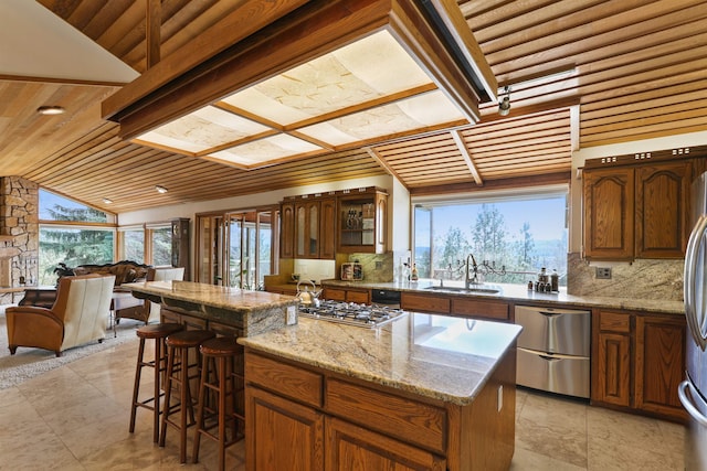 7816 E Gunning Ln, Spokane, WA 99212 - kitchen with tasteful backsplash, a center island, open floor plan, a breakfast bar, and stainless steel appliances