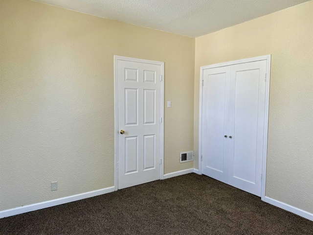 unfurnished bedroom with dark carpet and visible vents