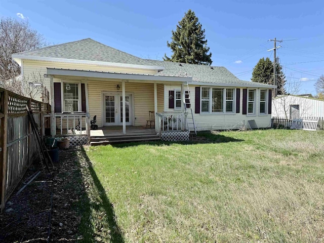 back of house featuring a yard, french doors, a fenced backyard, and roof with shingles