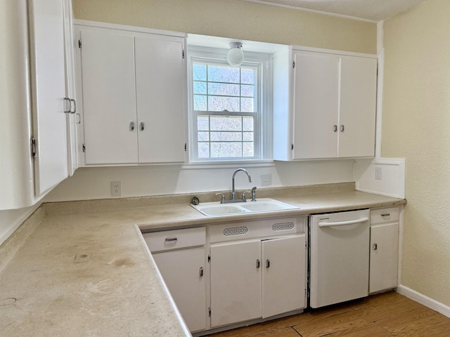 kitchen featuring white cabinets, dishwasher, a sink, light countertops, and light wood-type flooring