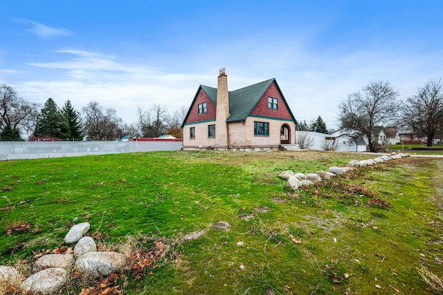 2612 N Elizabeth Rd, Spokane Valley, WA 99212 - view of home's exterior featuring a chimney, fence, and a lawn