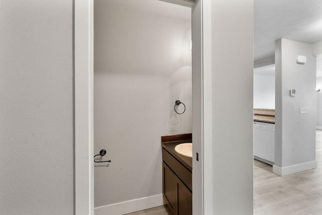 bathroom featuring vanity, baseboards, and wood finished floors