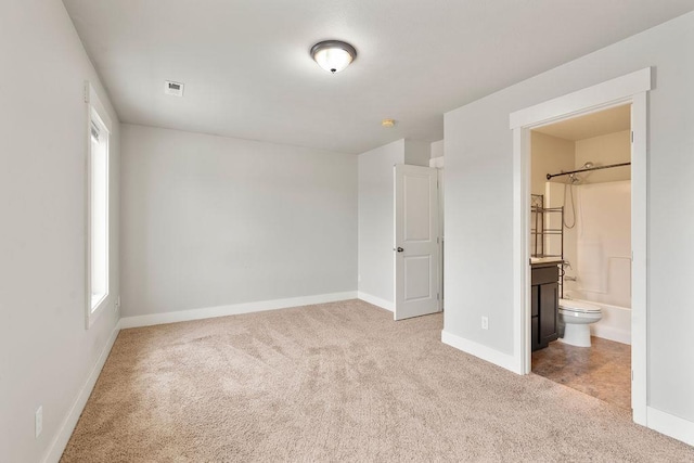 unfurnished bedroom with visible vents, baseboards, ensuite bathroom, and carpet