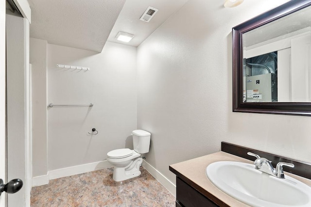 bathroom with toilet, vanity, baseboards, and visible vents