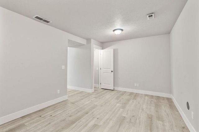unfurnished room featuring light wood finished floors, baseboards, and visible vents