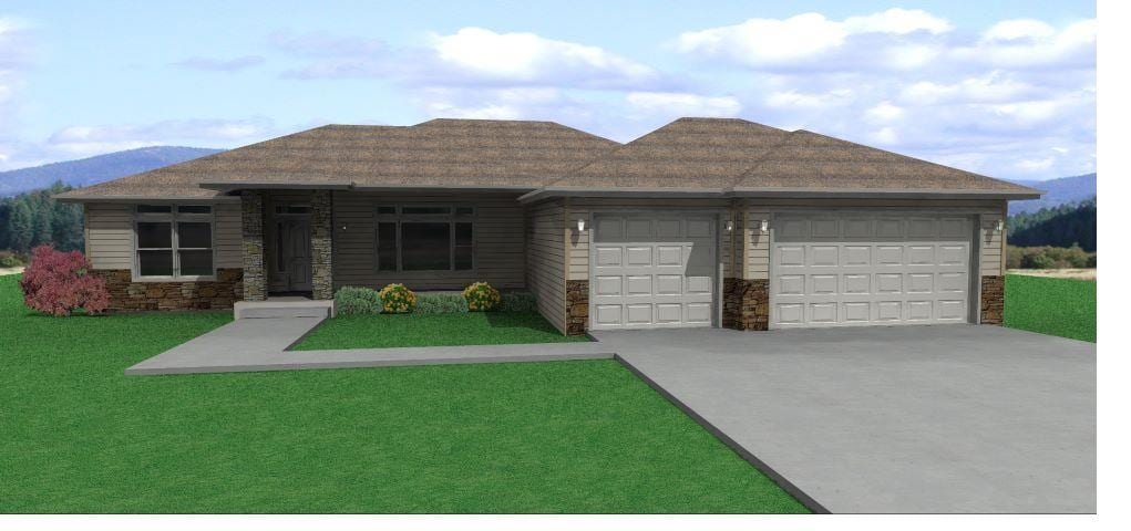 view of front of house featuring concrete driveway, a mountain view, stone siding, an attached garage, and a front yard