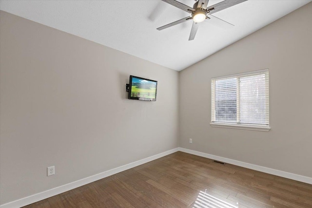 619 W Persimmon Ln, Spokane, WA 99224 - spare room featuring baseboards, visible vents, dark wood-style flooring, and vaulted ceiling