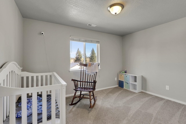 bedroom featuring carpet, baseboards, and a textured ceiling